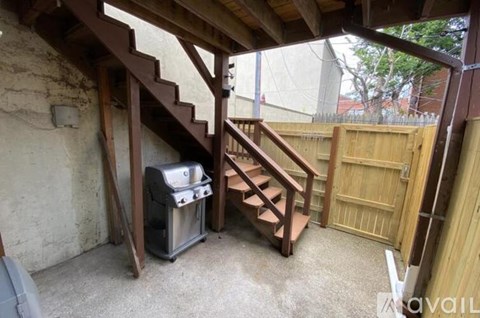 A staircase with a metal trash can underneath it.