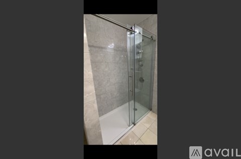 A glass shower stall with a white floor.