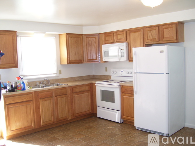A kitchen with wooden cabinets and white appliances.