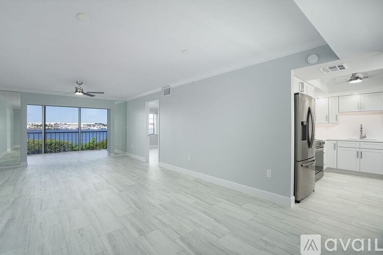 A spacious kitchen with a refrigerator, cabinets, and a countertop is available for rent.