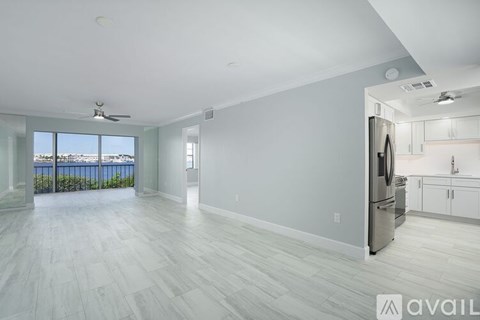 A spacious kitchen with a refrigerator, cabinets, and a countertop is available for rent.
