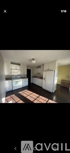 A kitchen with white cabinets and a refrigerator.