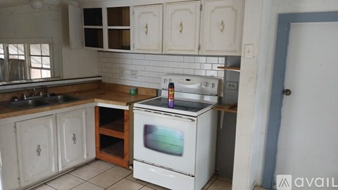 A white oven is in a kitchen with white cabinets.