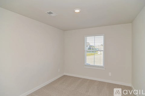 A room with a window and a carpeted floor.
