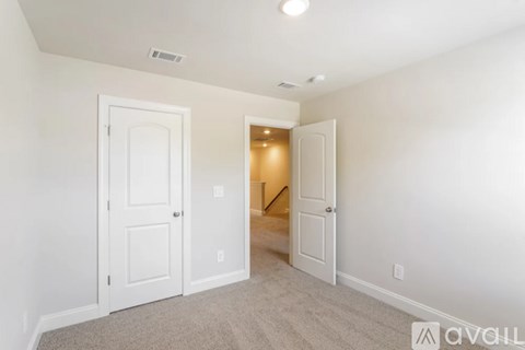 A room with two white doors and a carpeted floor.