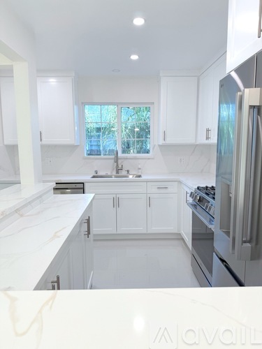 A kitchen with white cabinets and appliances.