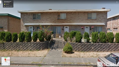 A house with a grey car parked in front.
