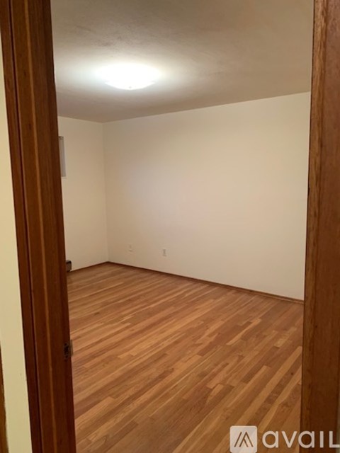 A room with wooden flooring and white walls.