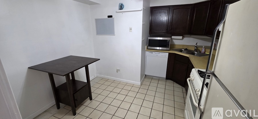 A kitchen with a table and a fridge.