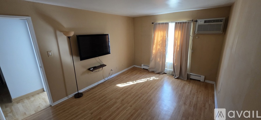 A living room with a flat screen TV mounted on the wall.