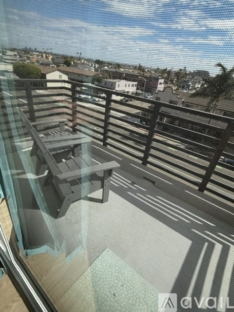 A balcony with a table and chairs overlooking a residential area.