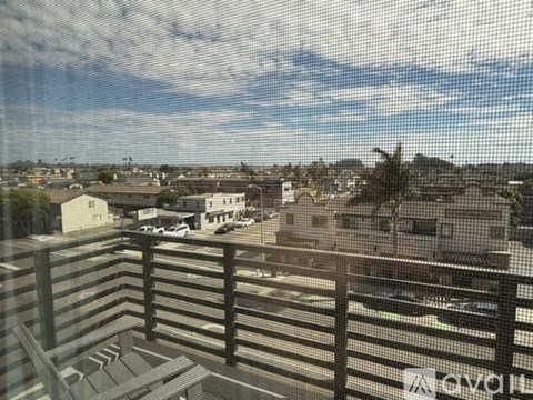 A view from a balcony overlooking a cityscape.