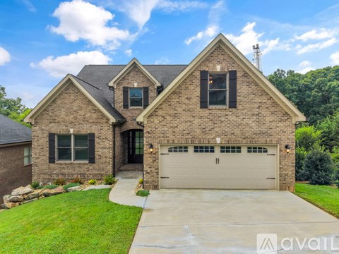 A house with a garage and a driveway in front.