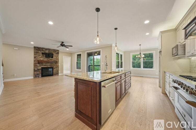 A spacious kitchen with wooden cabinets and a stone fireplace.