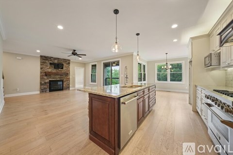 A spacious kitchen with wooden cabinets and a stone fireplace.