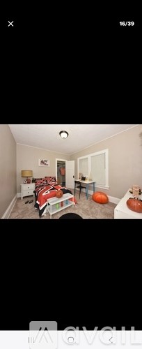A bedroom with a bed, desk, and chair.