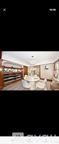 A modern dining room with a white table and chairs.