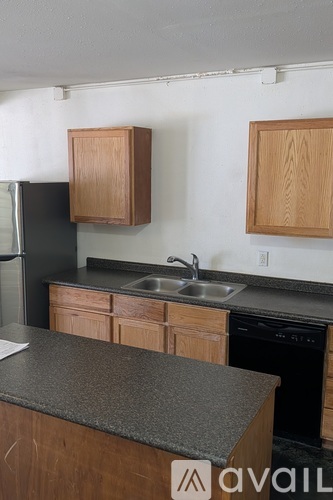 A kitchen with wooden cabinets and a granite countertop.