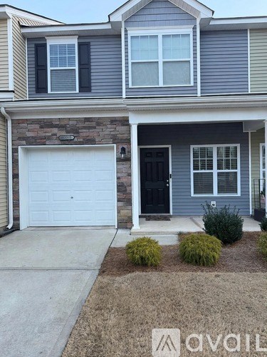 A house with a white garage door and a black front door.