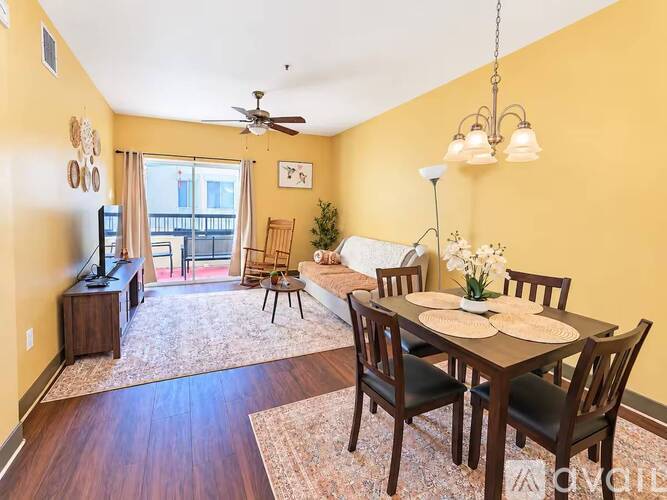 A living room with a dining table set up with plates and flowers.