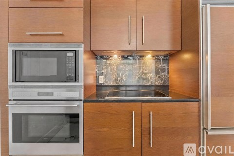 A kitchen with wooden cabinets and a stainless steel oven.
