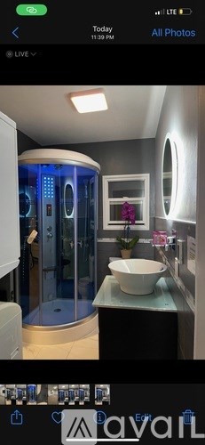 A modern bathroom with a round mirror and a glass shower stall.