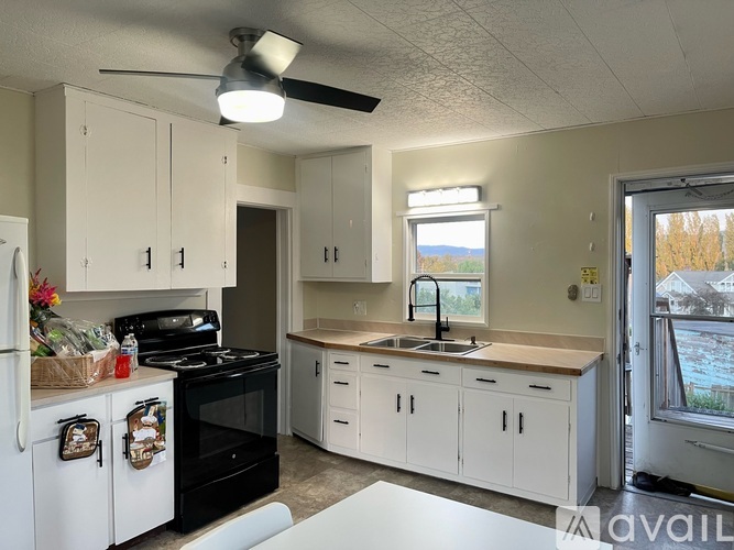A kitchen with white cabinets and a black stove top oven.