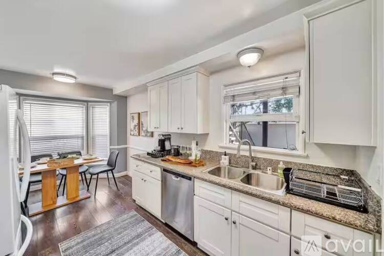 A kitchen with white cabinets and a granite countertop.
