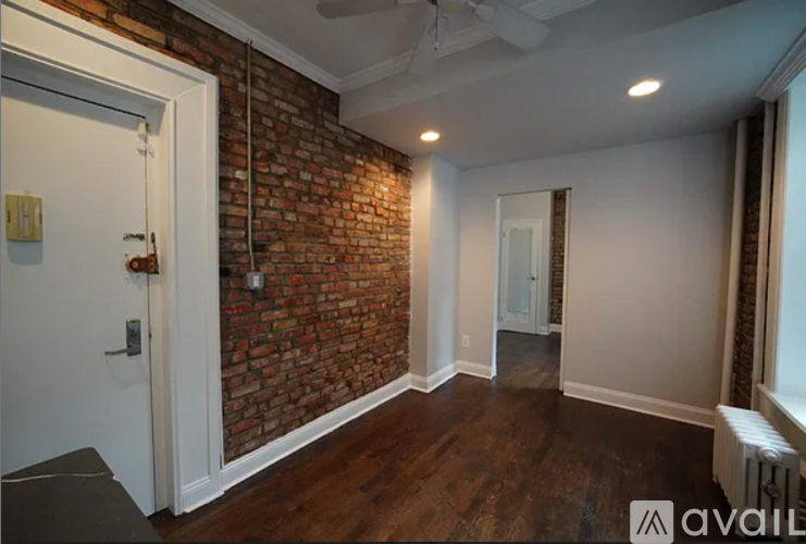 A room with a brick wall and a ceiling fan.