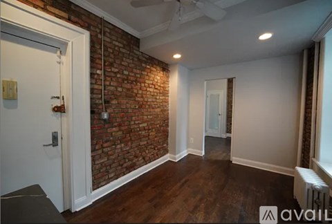 A room with a brick wall and a ceiling fan.