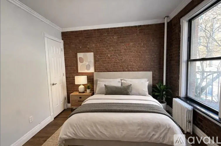 A bedroom with a brick wall and a large bed.