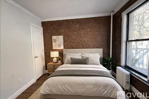 A bedroom with a brick wall and a large bed.