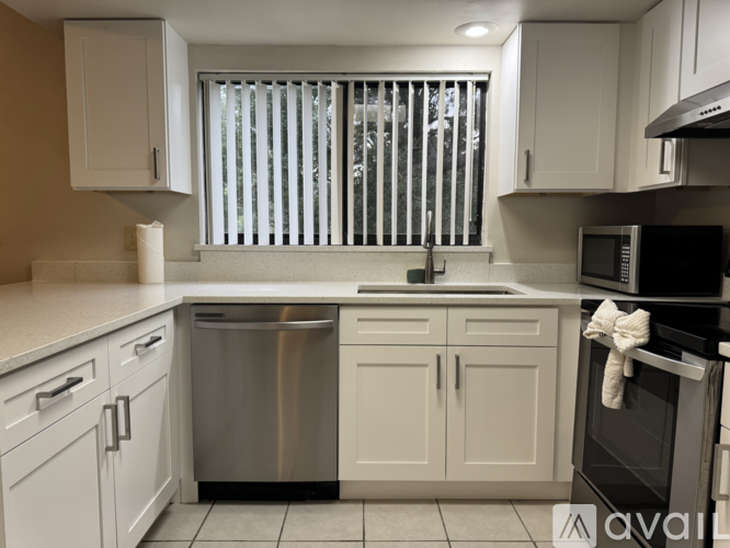 A kitchen with white cabinets and a stainless steel dishwasher.