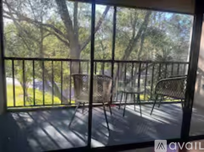 A balcony with a metal railing and a view of trees.
