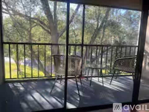 A balcony with a metal railing and a view of trees.