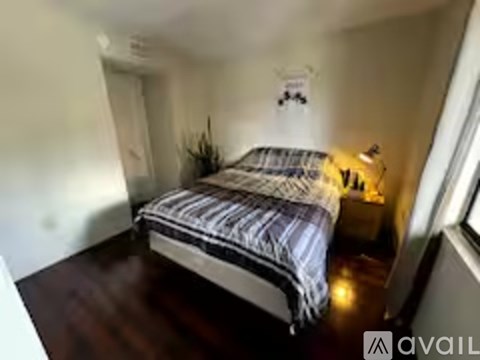 A bedroom with a bed and a lamp.