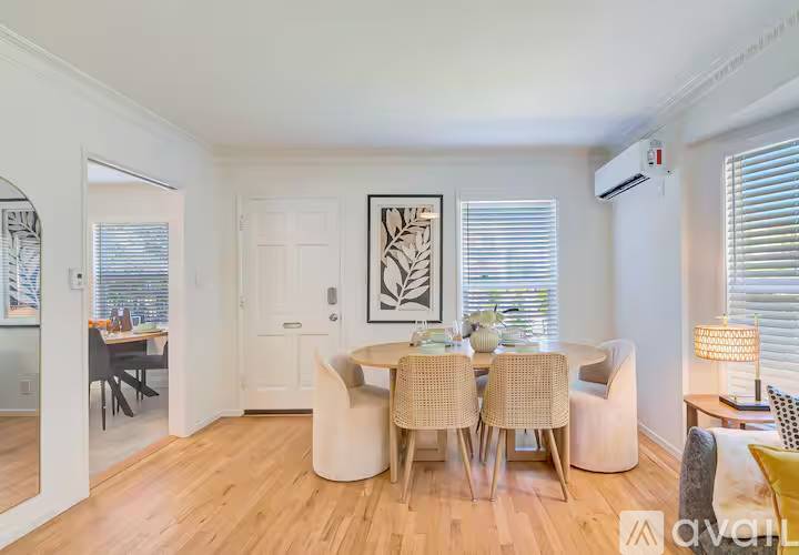 A dining room with a white table and chairs.