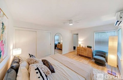 A bedroom with a large bed and a painting on the wall.