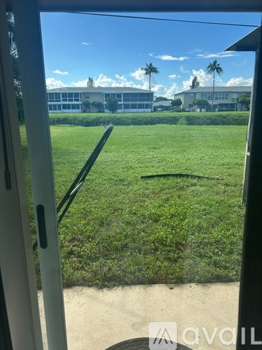 A view from inside a vehicle looking out onto a grassy field.