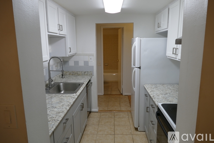 A kitchen with white cabinets and a sink.