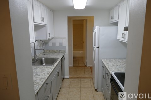 A kitchen with white cabinets and a sink.