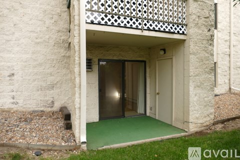 A balcony with a green floor and a doorway leading to another room.