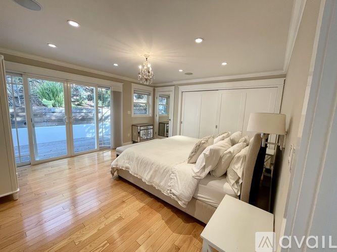 A bedroom with a large bed and a chandelier.