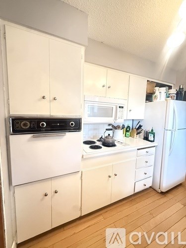 A kitchen with white appliances and cabinets.