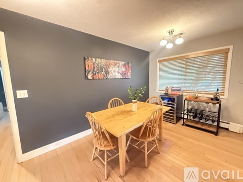 A dining room with a wooden table and chairs.