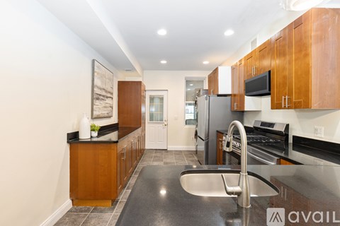 A kitchen with wooden cabinets and a black countertop.