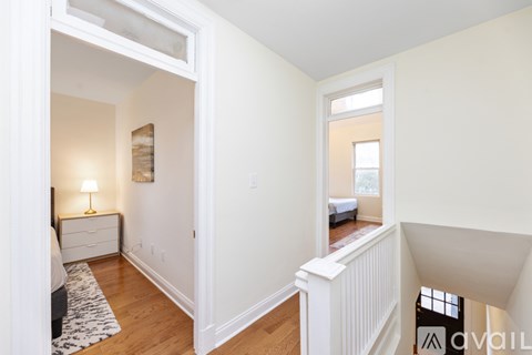 A bedroom with a bed, nightstand, lamp, and a dresser with a mirror.