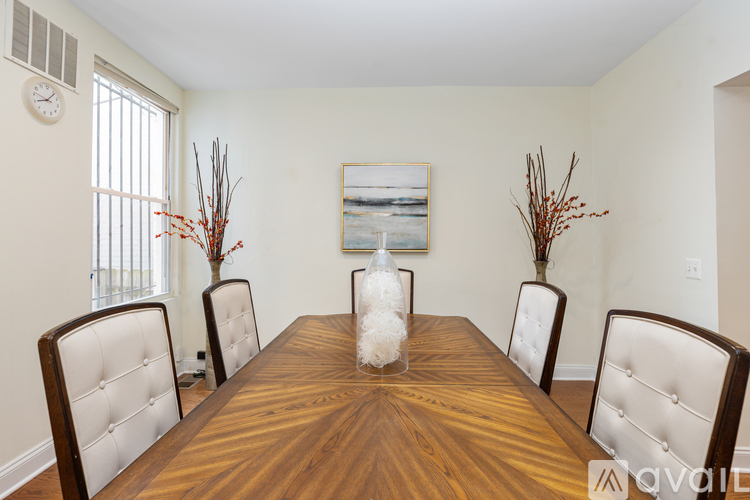 A dining room with a wooden table and chairs.