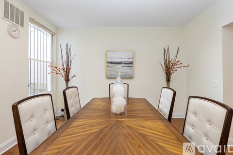 A dining room with a wooden table and chairs.