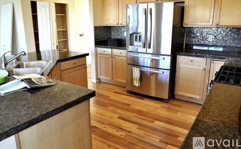 A kitchen with wooden cabinets and a black granite countertop.